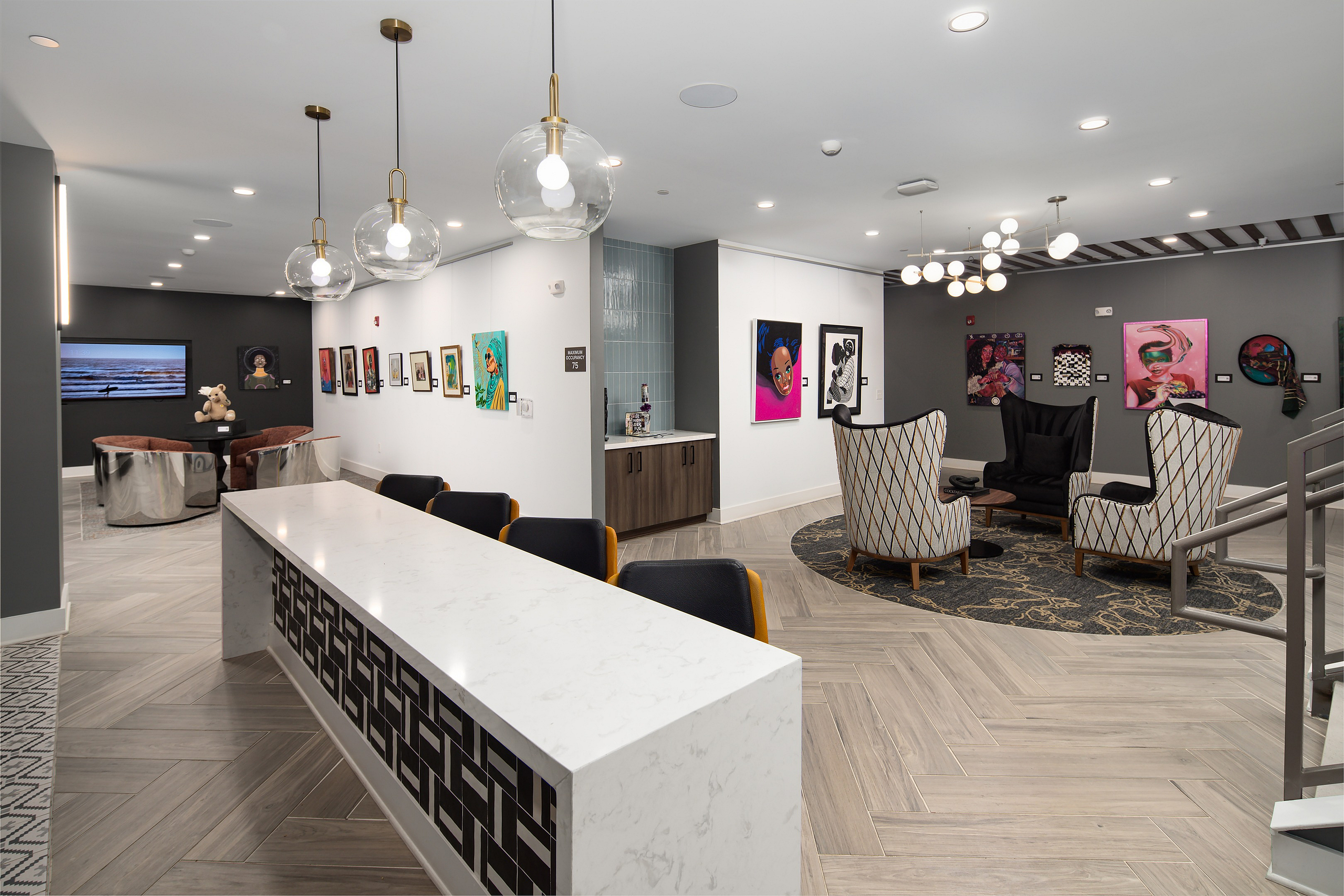 Chic lounge area with stylish seating, contemporary artwork, and elegant lighting in a modern apartment building.