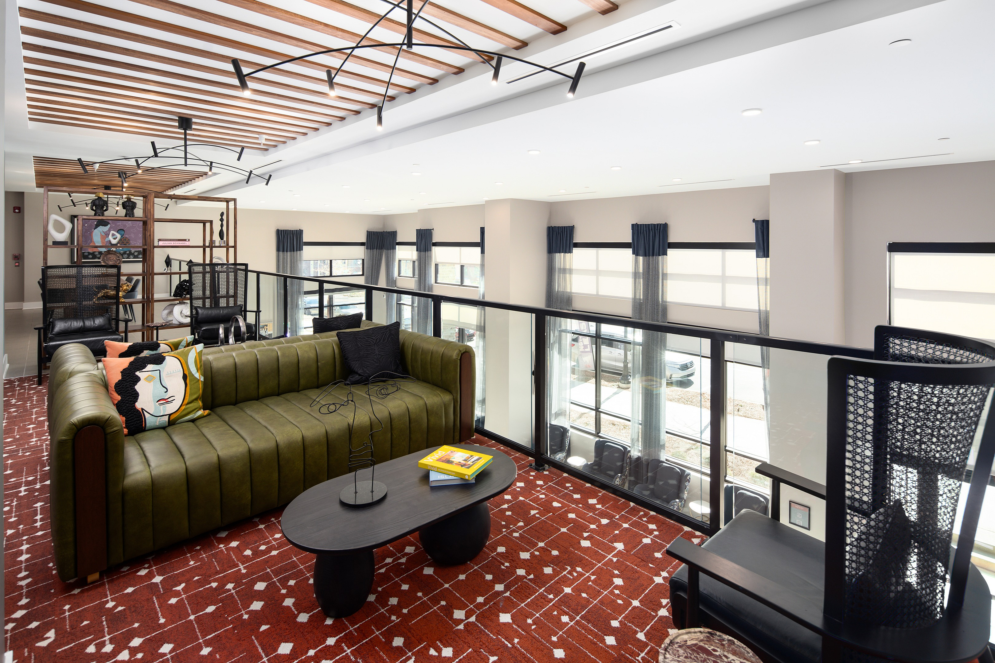 Chic open-concept living area with elegant modern furniture, vibrant decor, and large windows providing natural light.
