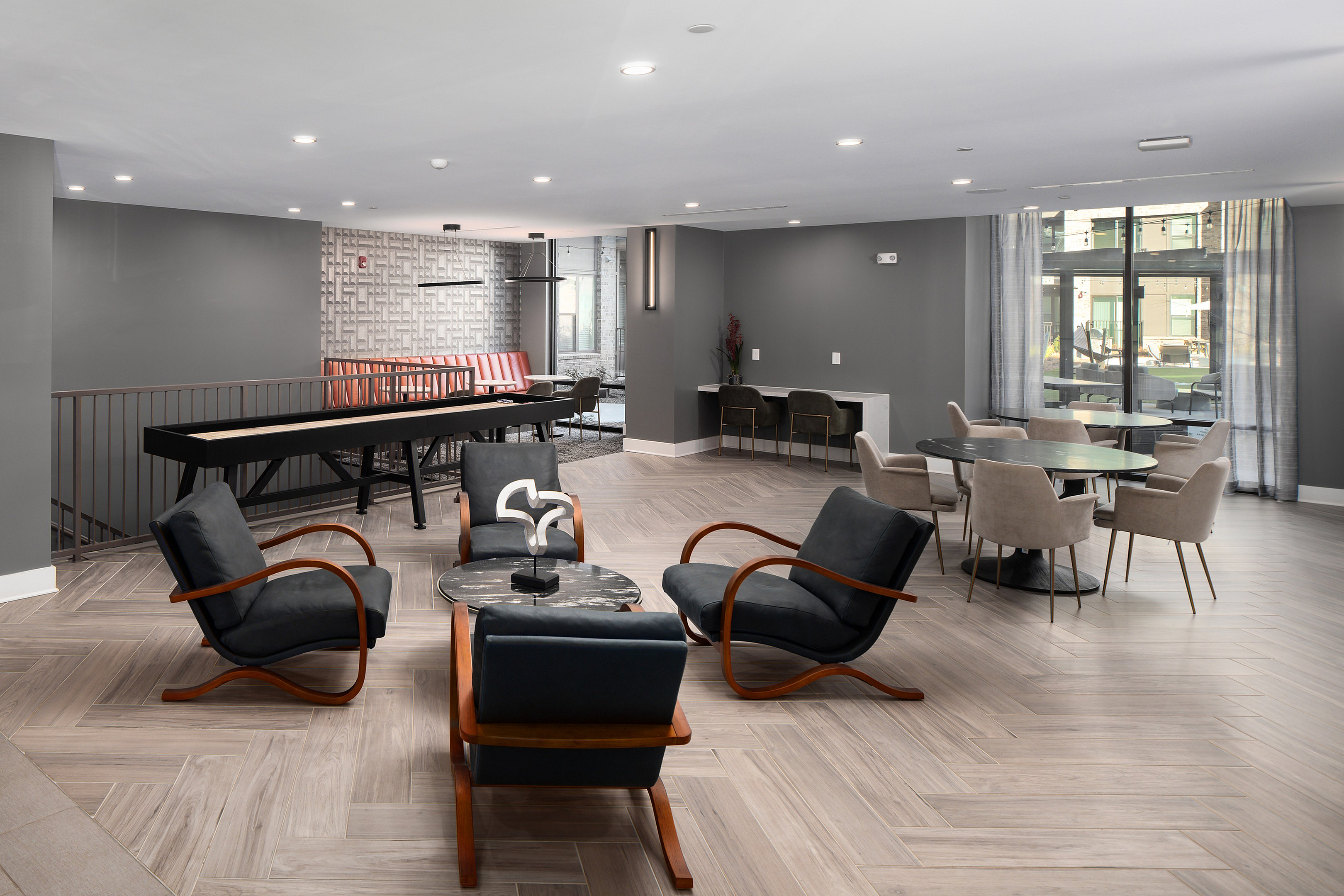 Modern lounge area with elegant seating, accent tables, and sleek floors, perfect for social gatherings or relaxation.