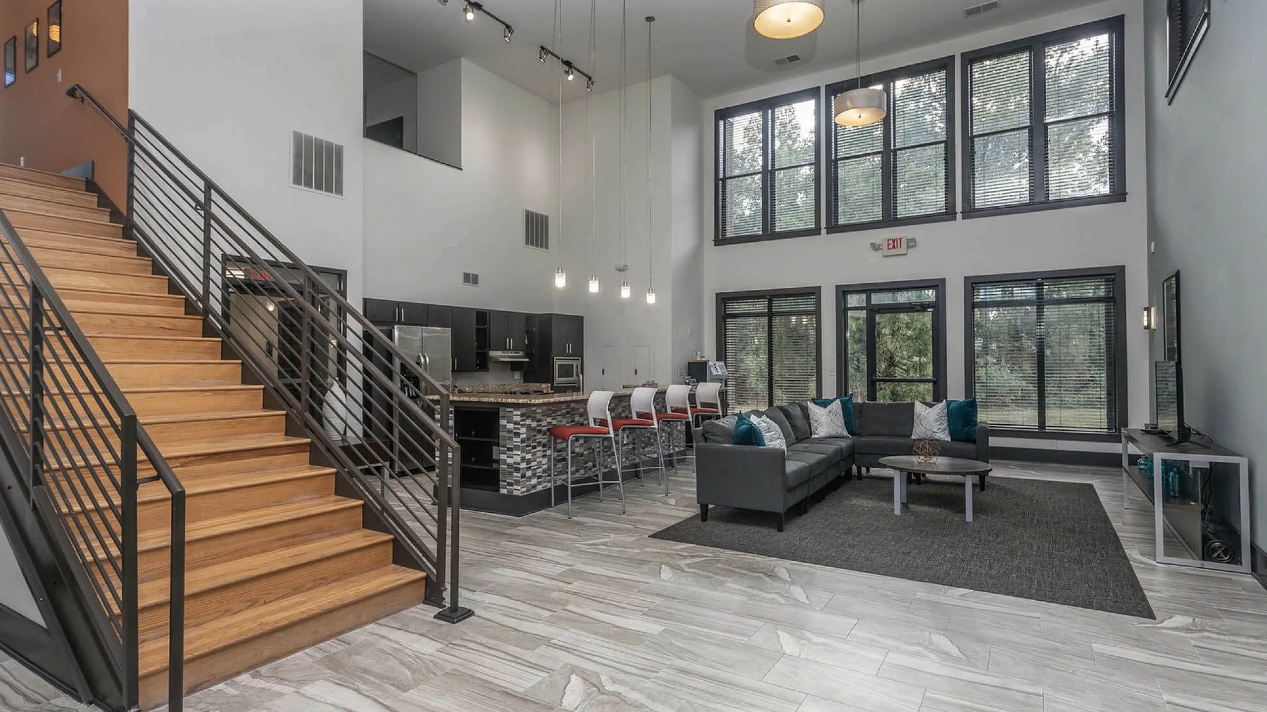 Spacious contemporary lounge with large windows, stylish kitchen, and cozy seating