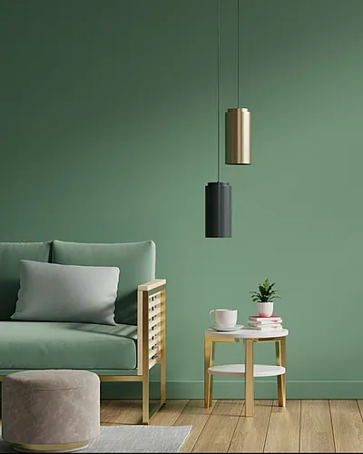 Modern living room with a stylish green couch, cozy ottoman, and elegant pendant lights.