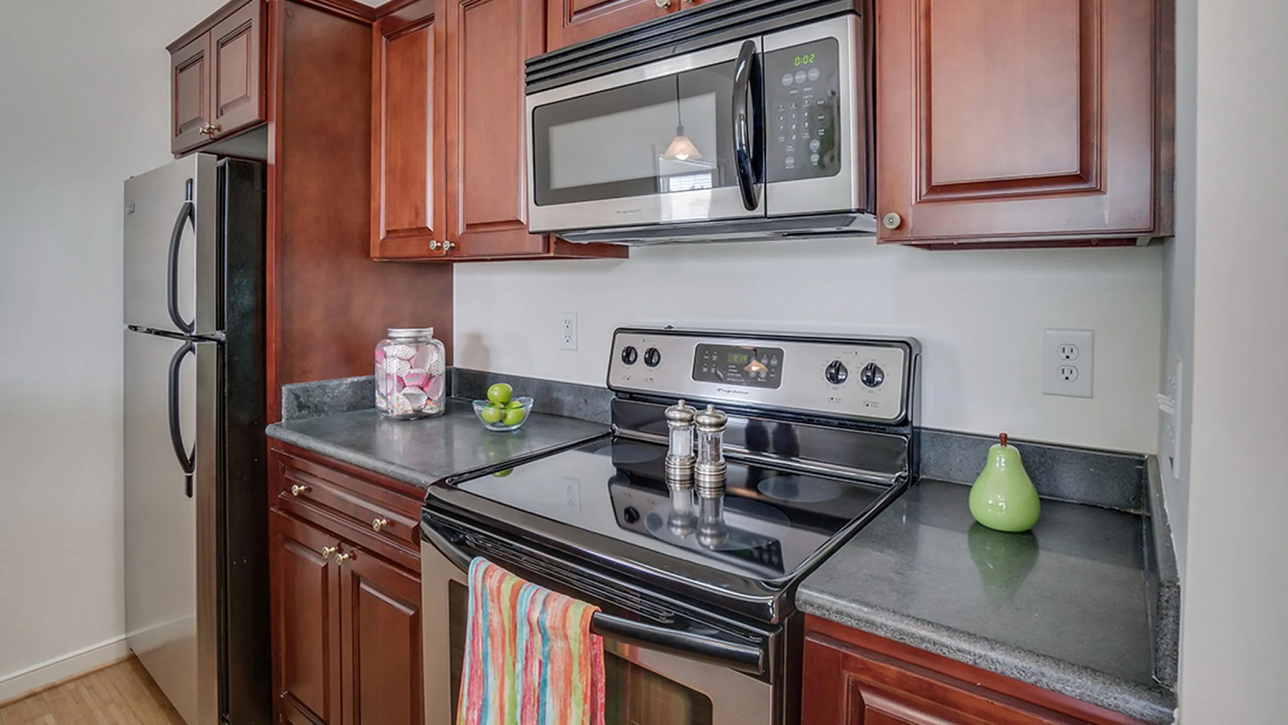 Modern kitchen with stainless steel appliances and wooden cabinets.