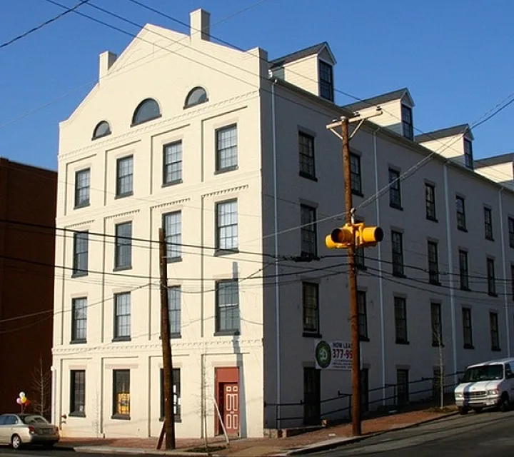 Attractive multi-story apartment building with classic architecture under a clear blue sky.