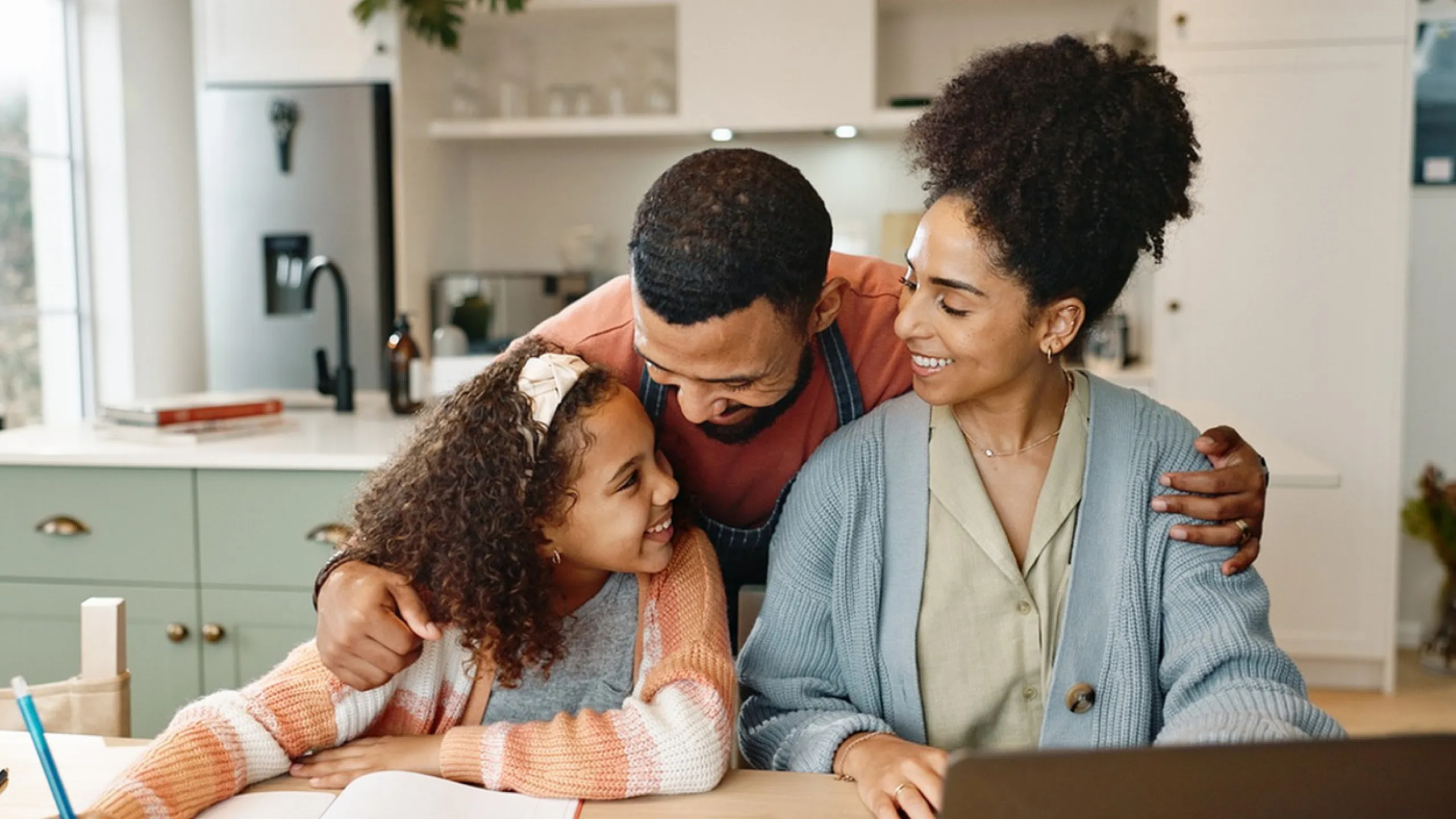 Happy family enjoying time together in a modern kitchen with bright lighting and elegant decor.
