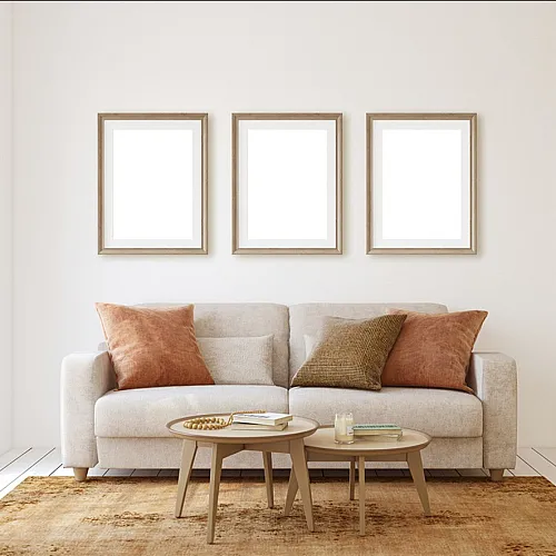 Inviting living room featuring a plush beige sofa with orange cushions, elegant coffee tables, and bright natural light.