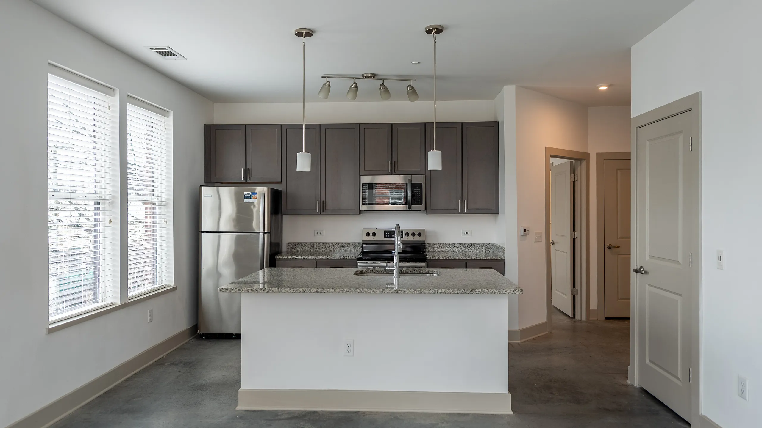 Modern kitchen with sleek cabinets, polished granite countertops, and stainless steel appliances.