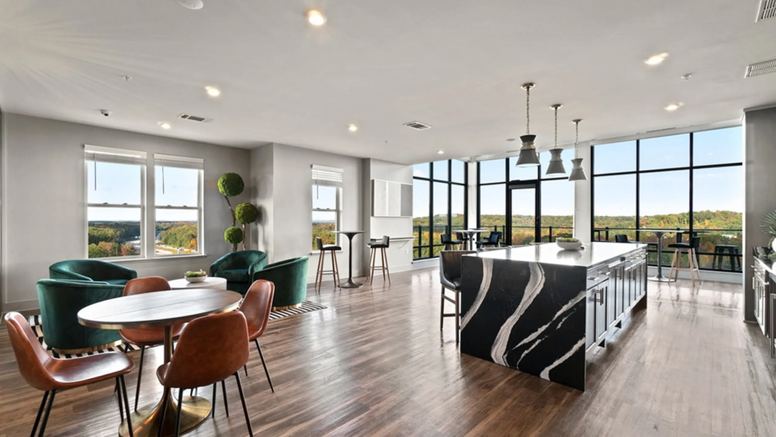 Beautiful open-concept apartment with a sleek kitchen island and a spacious dining area boasting panoramic windows.