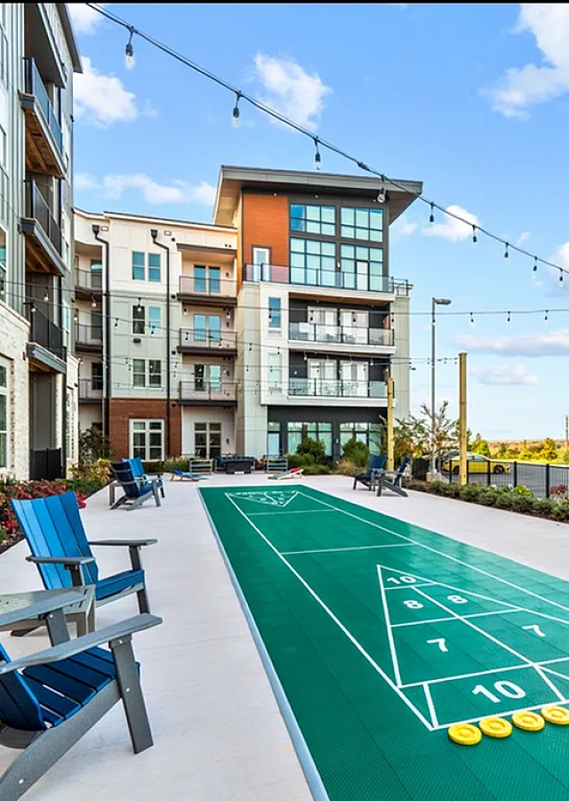 Chic apartment complex with outdoor shuffleboard and cozy seating areas.