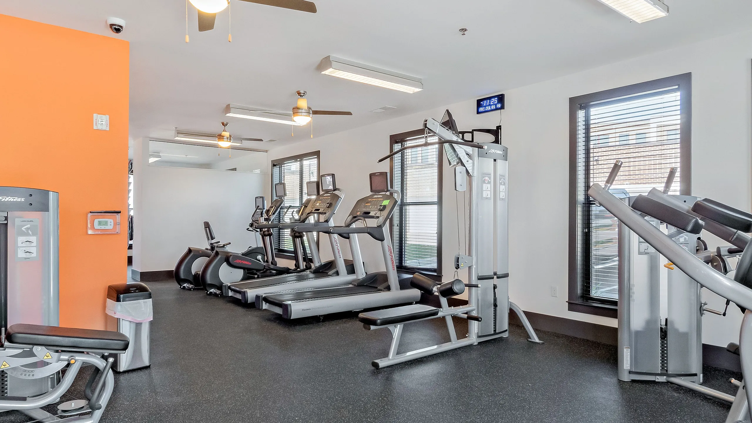 Bright, modern fitness center equipped with treadmills, exercise bikes, and strength training machines.