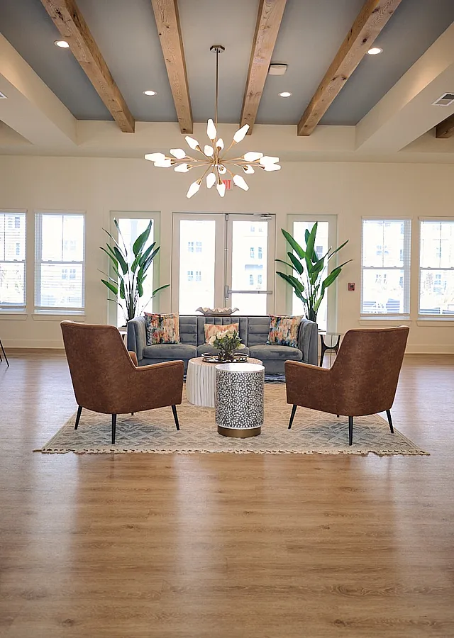 Stylish and inviting lounge area with cozy seating, wood beam ceiling, and indoor plants.