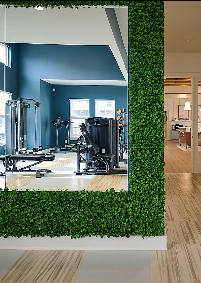 Modern gym facility with fitness equipment and spacious interior with mirrored walls.