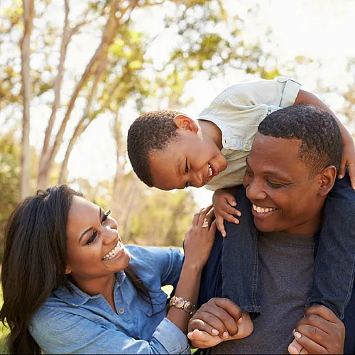 A cheerful family enjoying time together outdoors in a sunny park.