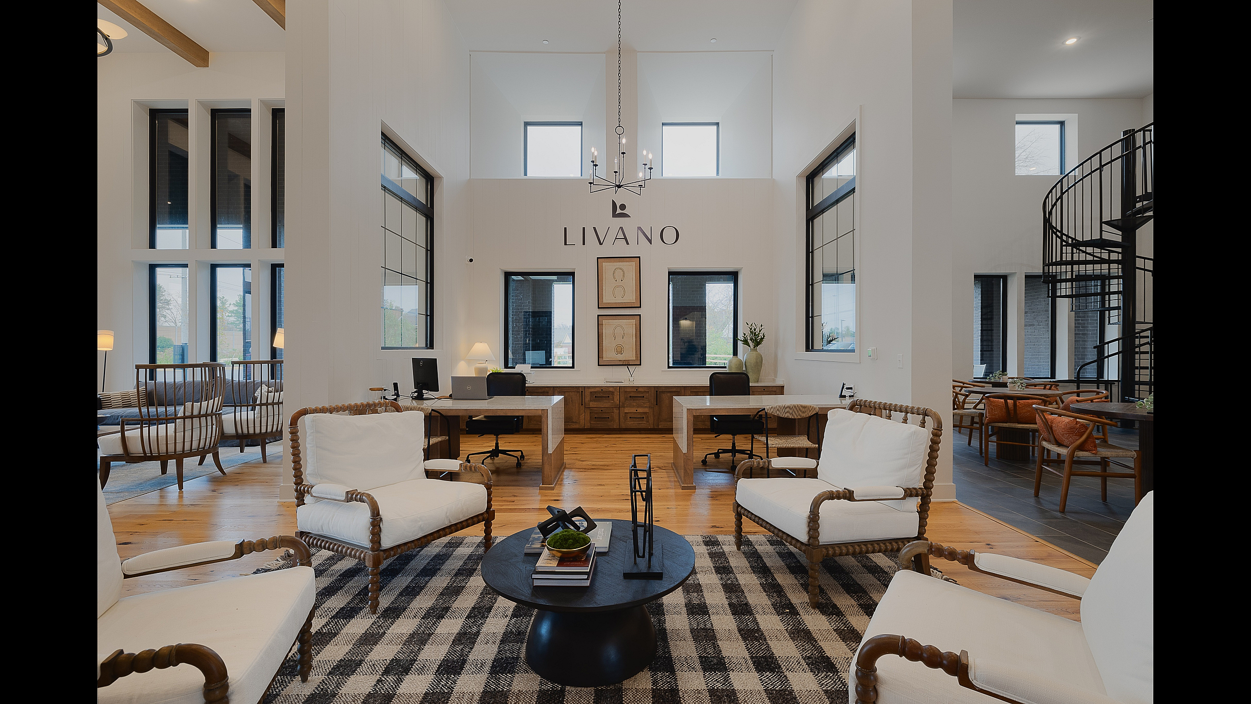 Elegant modern lobby with high ceilings, contemporary furnishings, and a stylish spiral staircase, exuding a welcoming ambiance.