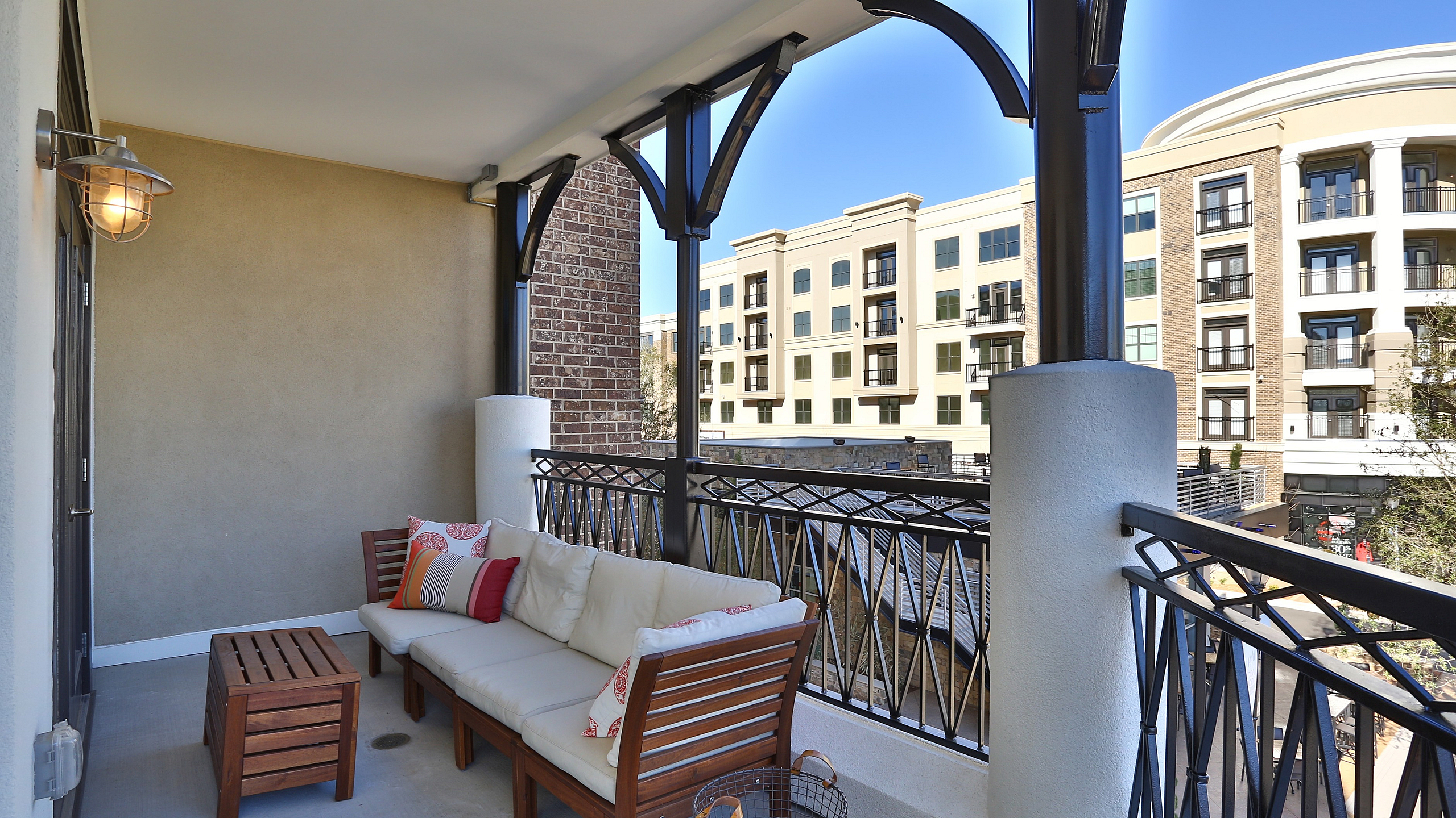 Charming balcony view with cozy seating, elegant metal railings, and modern architecture backdrop.