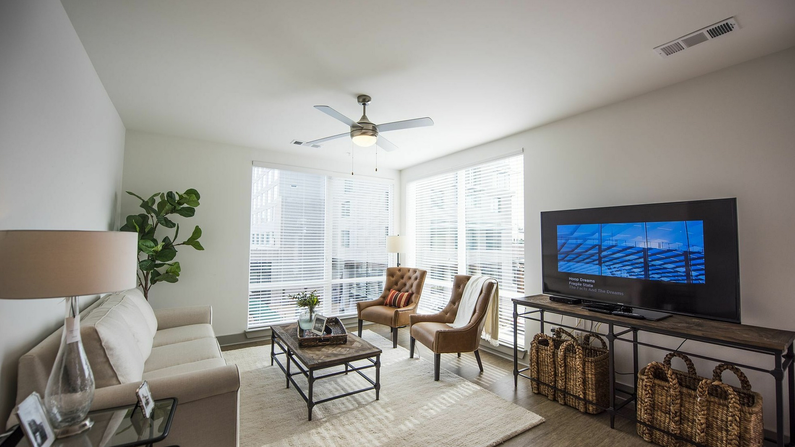 Elegant living room with large windows, modern furniture, and stylish decor creating a bright and inviting space.