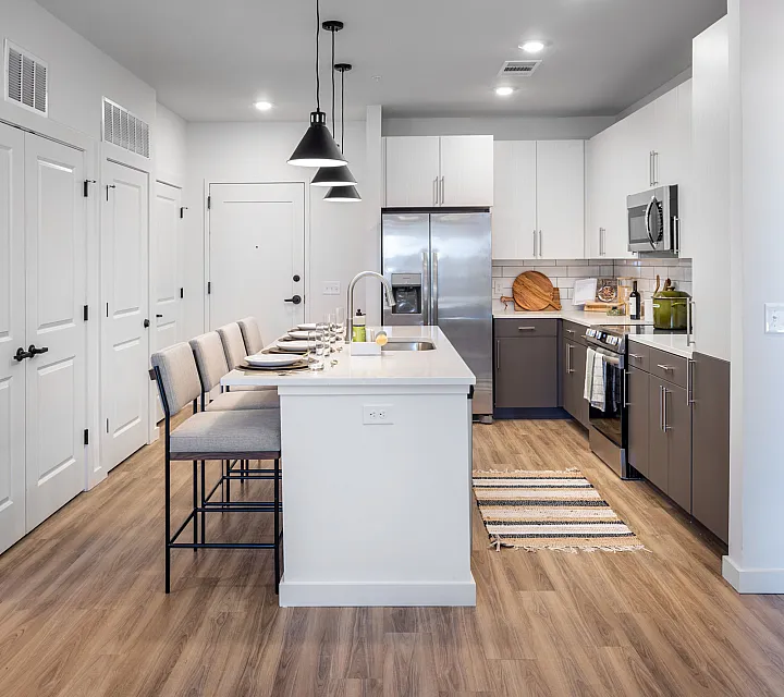 Modern kitchen with sleek cabinetry, stainless steel appliances, and a chic island with bar seating, ideal for entertaining.