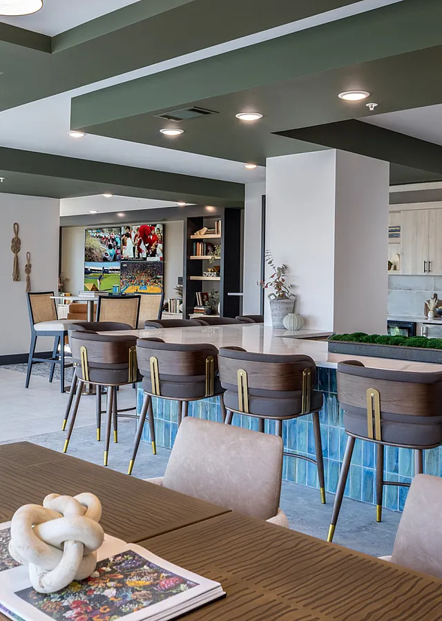 Modern open-concept lounge with elegant dining area, stylish bar seating, and a large TV for entertainment.