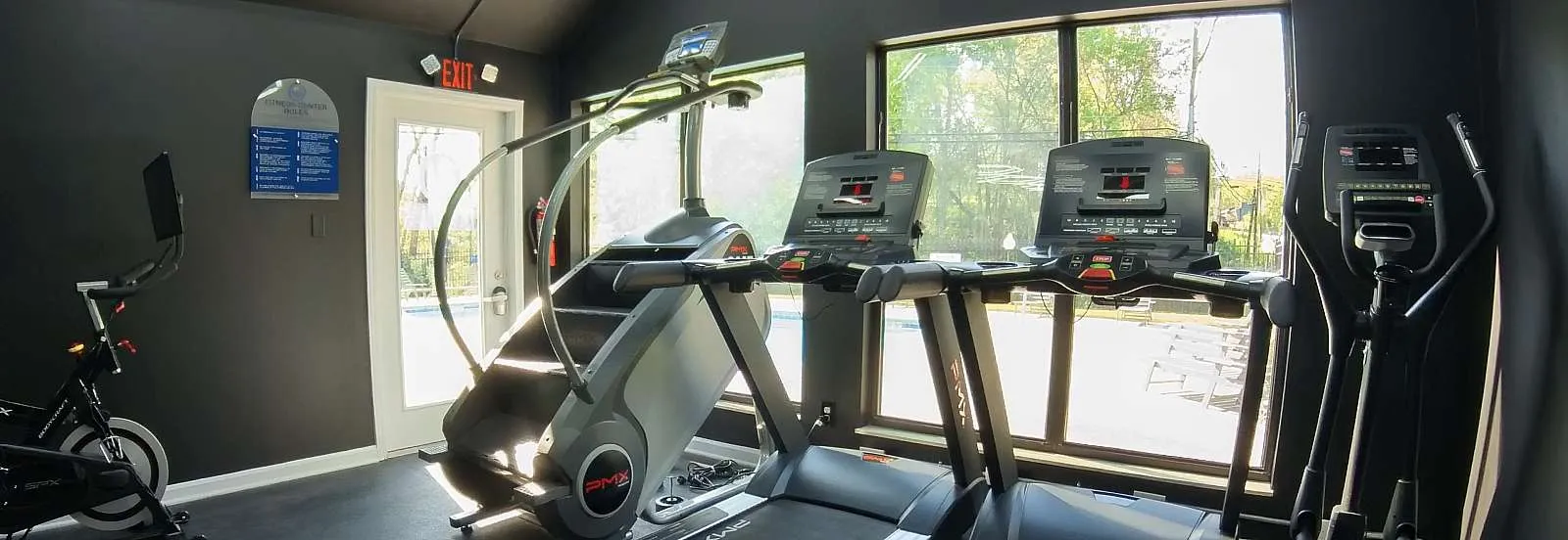 Contemporary fitness center with state-of-the-art gym equipment and large windows for natural light.