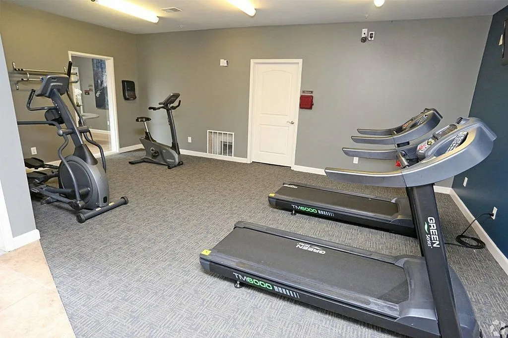 Modern, fully-equipped gym room with state-of-the-art treadmills and exercise bikes.