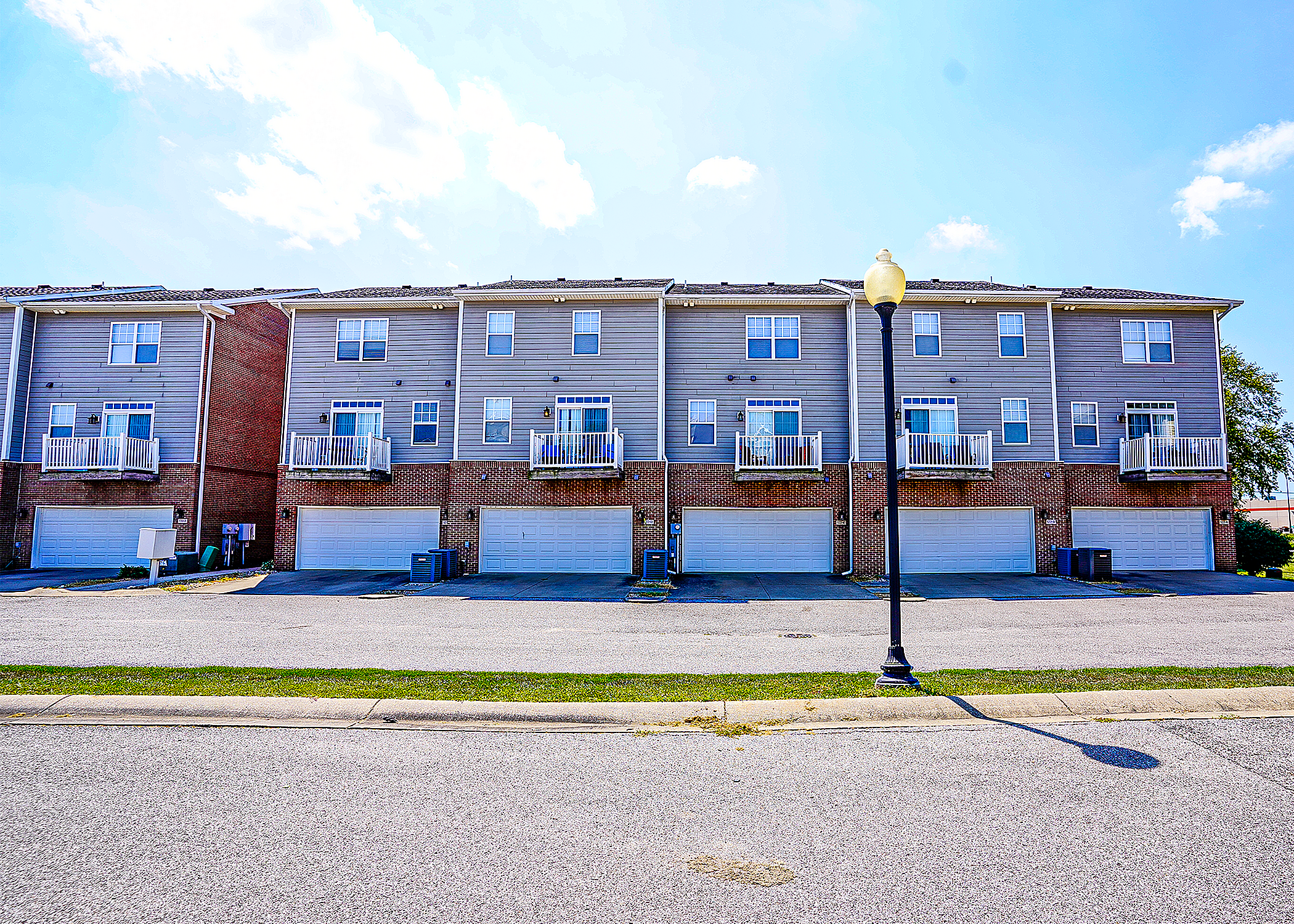 Charming row of modern townhomes with private balconies and spacious garages, perfect for family living.