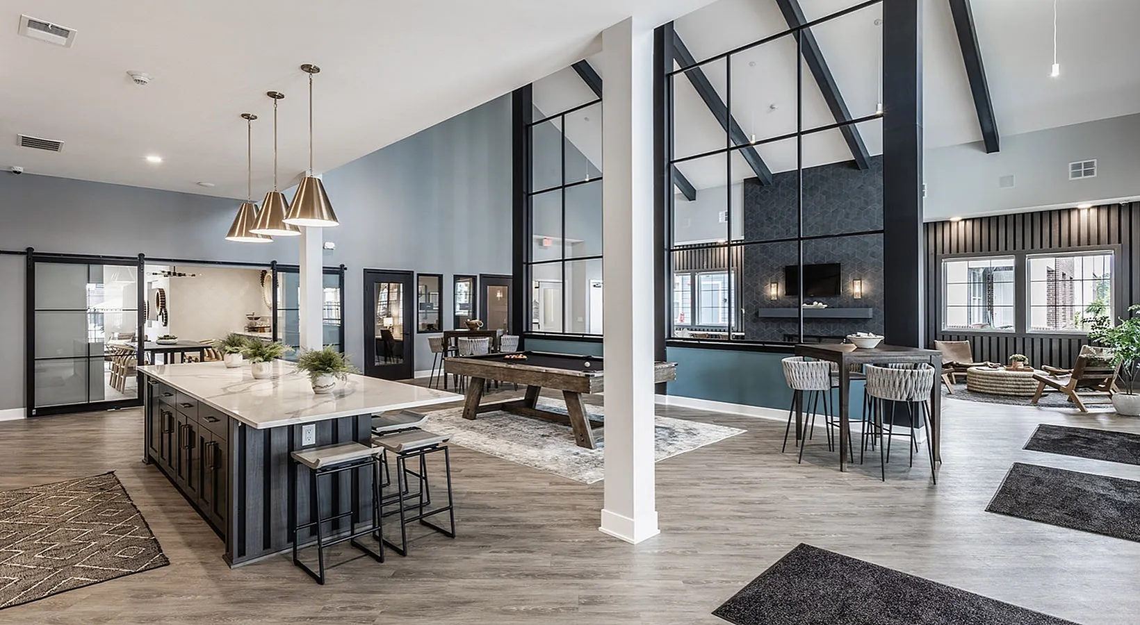 Luxurious and spacious open-concept living area featuring a stylish kitchen island with modern pendant lighting, elegant seating, and a cozy lounge with a pool table. Perfect for entertaining and relaxation.