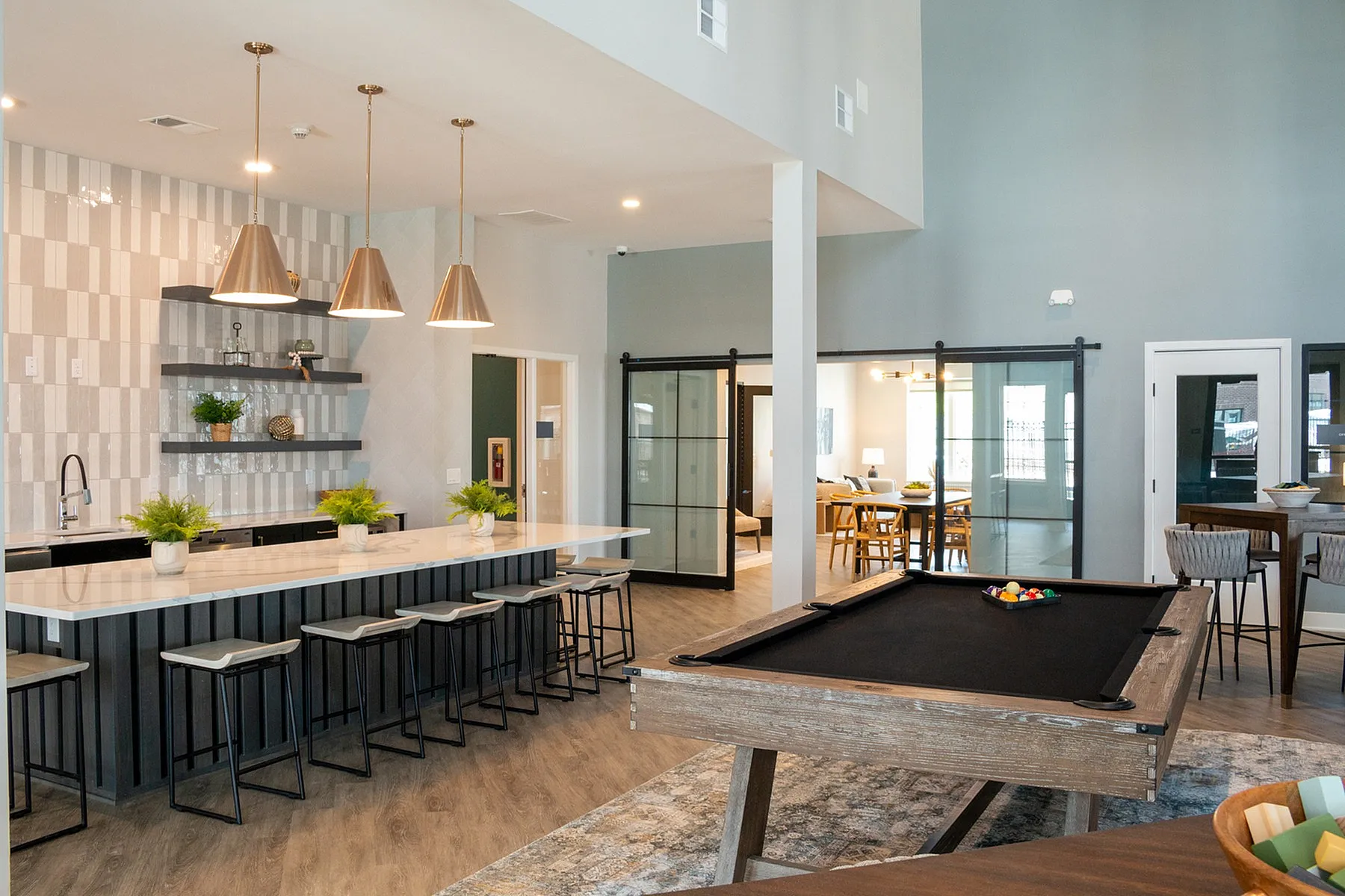 Sleek and modern communal area with a stylish kitchen, elegant bar seating, and a cozy dining space ideal for socializing.