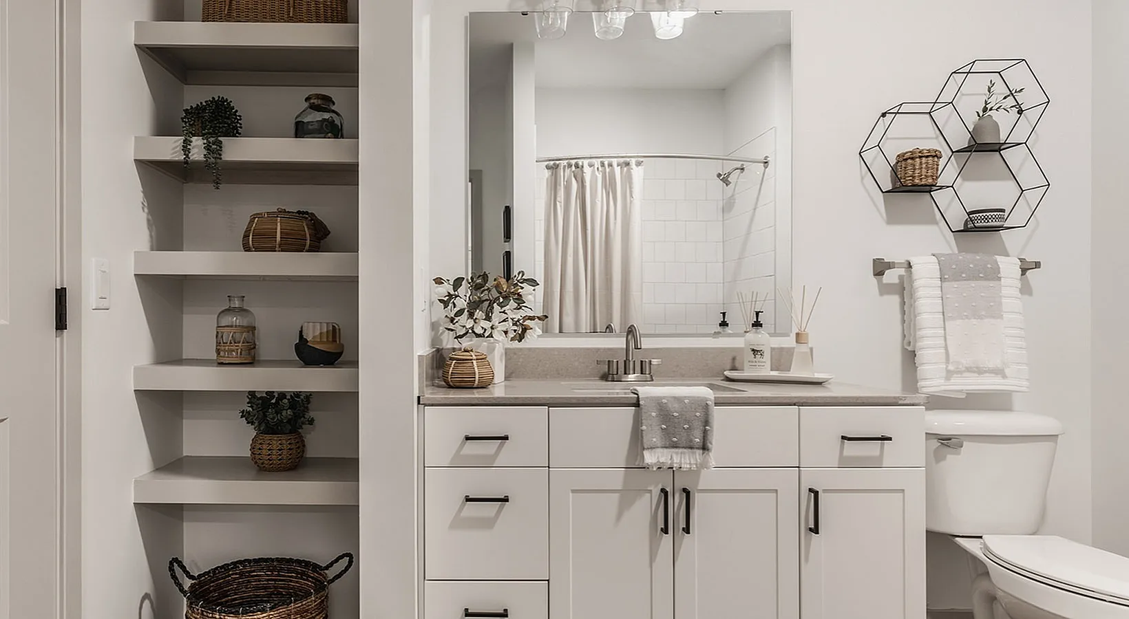 Modern bathroom with elegant open shelving and stylish decor, featuring a sleek vanity and minimalist accents.