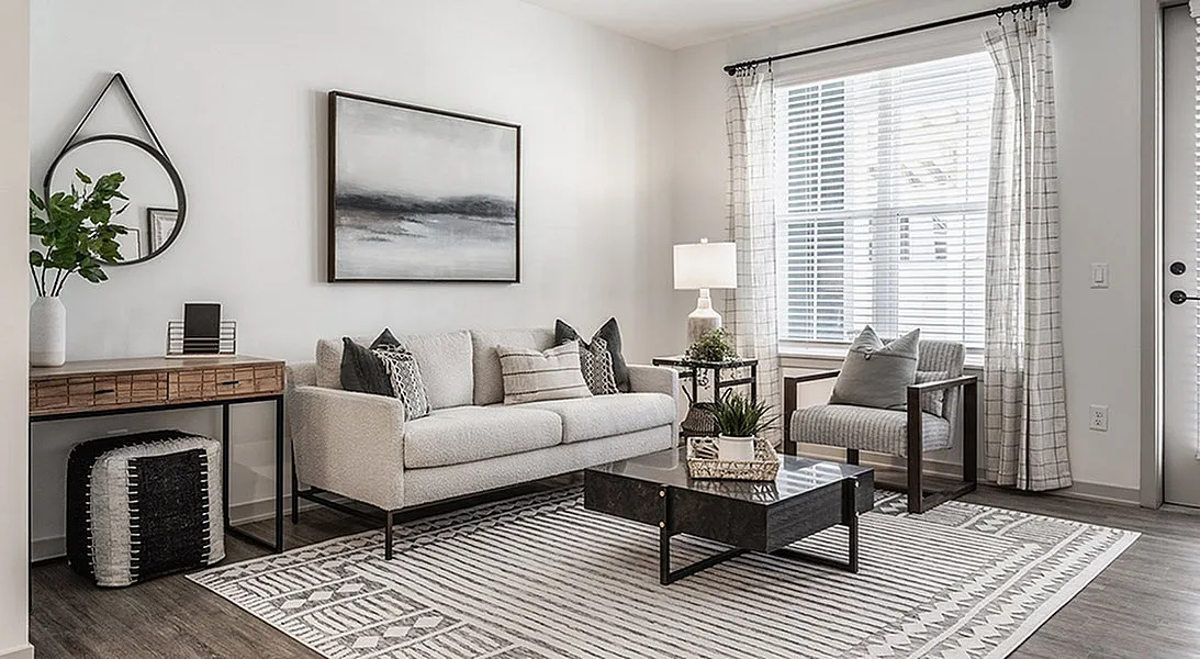 Modern and elegant living room featuring a plush sofa, sleek coffee table, and large window inviting natural light.