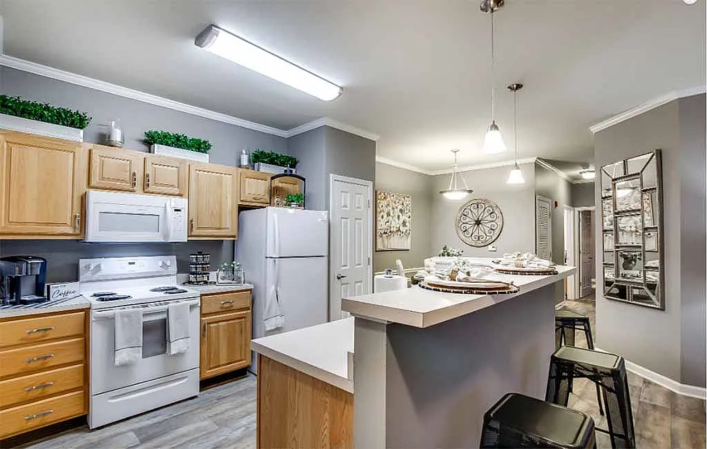 Modern kitchen with stylish wooden cabinets, sleek countertop, and cozy pendant lighting, offering a warm dining ambiance.