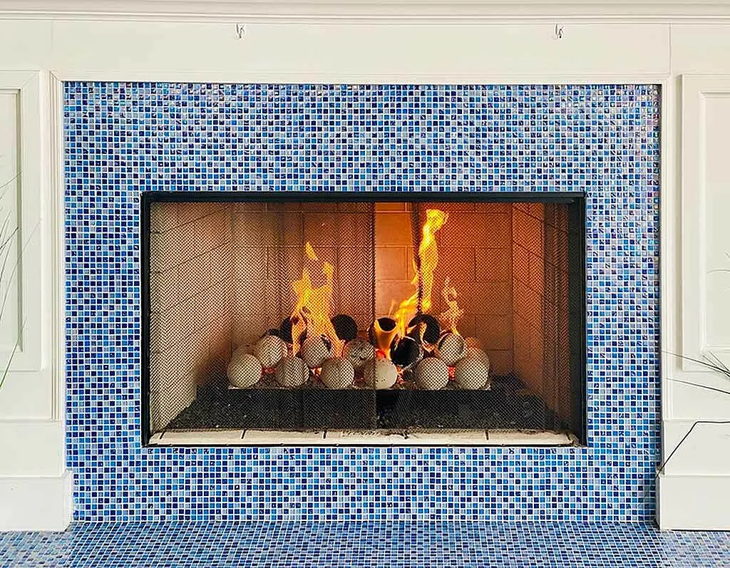 Inviting fireplace with vibrant blue mosaic tile surround, creating a cozy and stylish atmosphere.
