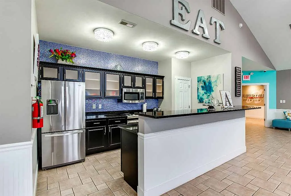 Modern kitchen with sleek stainless steel appliances, vibrant blue mosaic backsplash, and inviting decor for a stylish cooking experience.