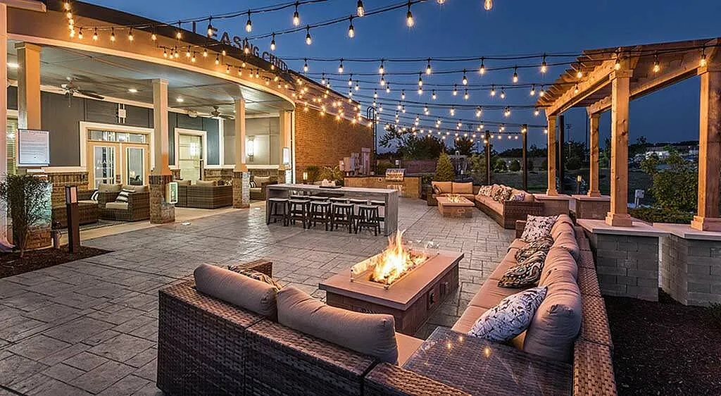 Charming outdoor patio with cozy seating, ambient string lights, and a warm fire pit, perfect for evening gatherings.