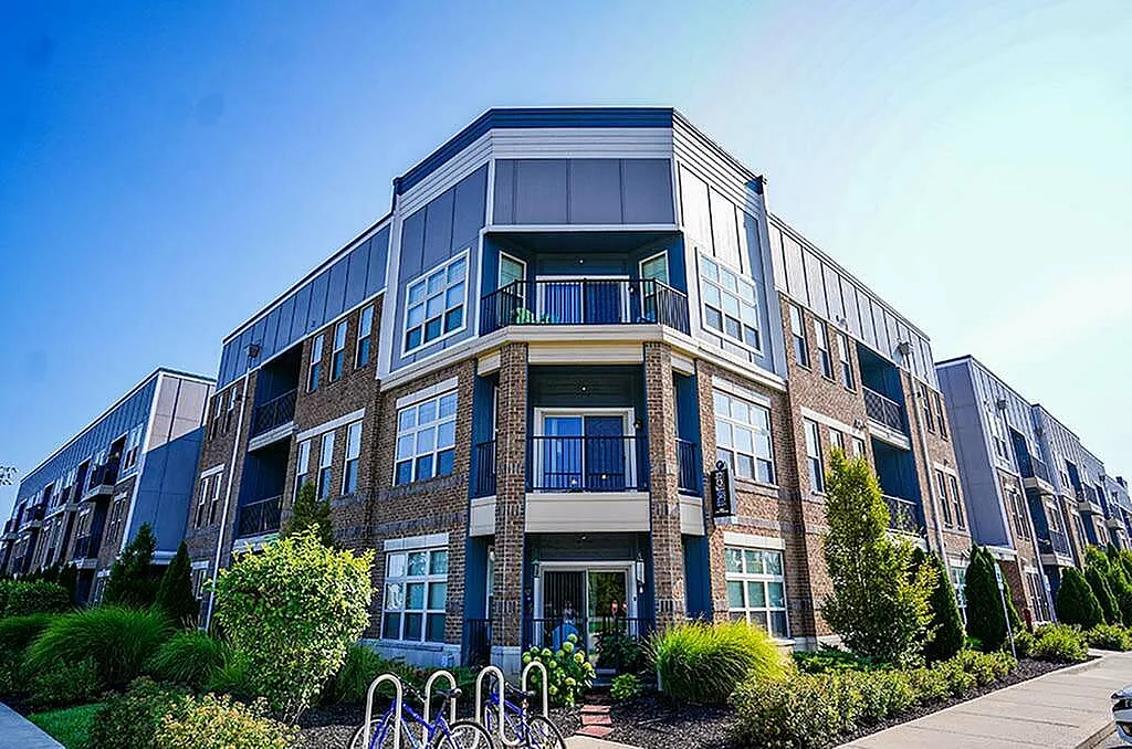 Contemporary apartment complex showcasing modern design, with lush landscaping and large windows for natural light.