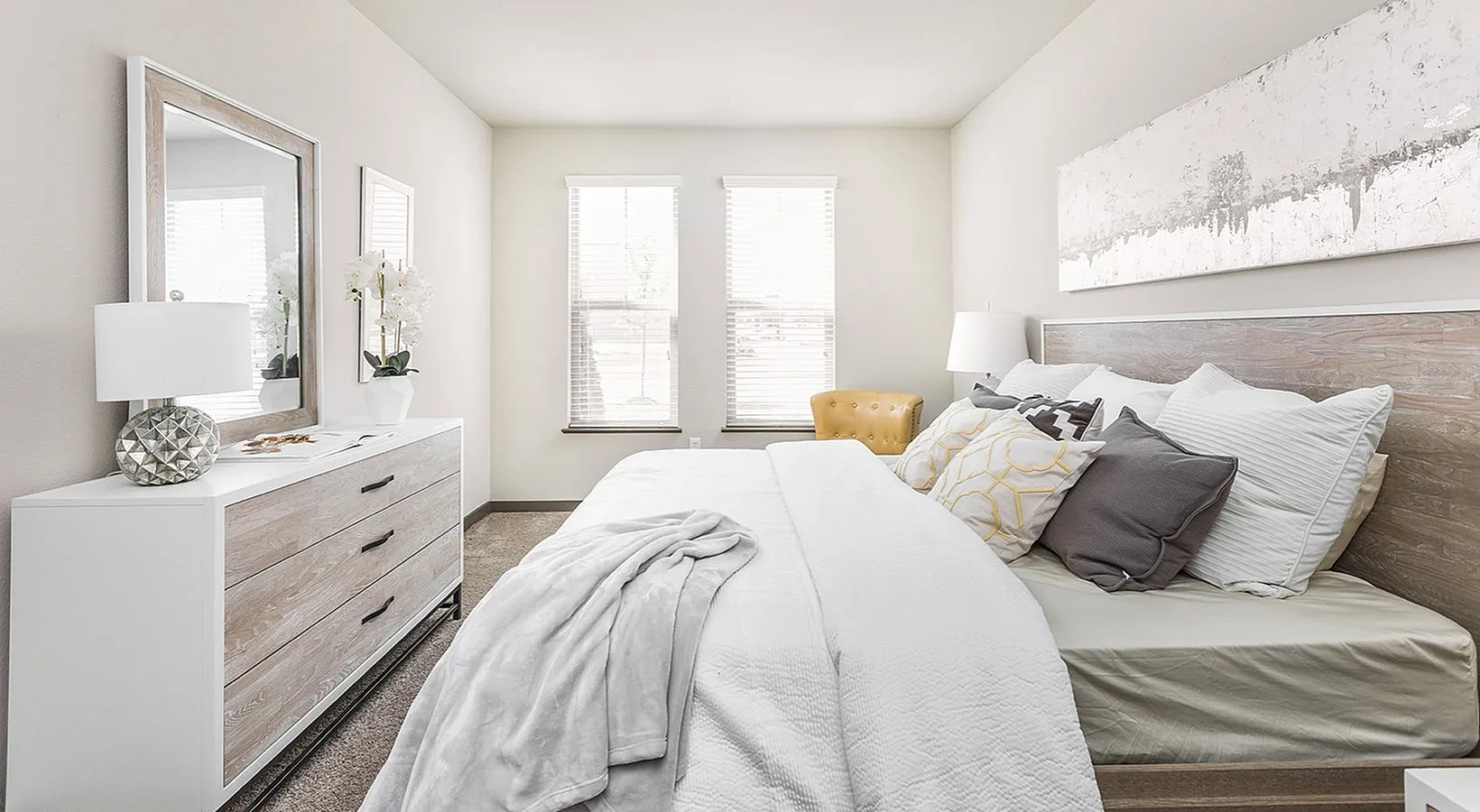 Bright and inviting bedroom with a cozy bed, elegant dresser, and stylish decor, perfect for relaxation.