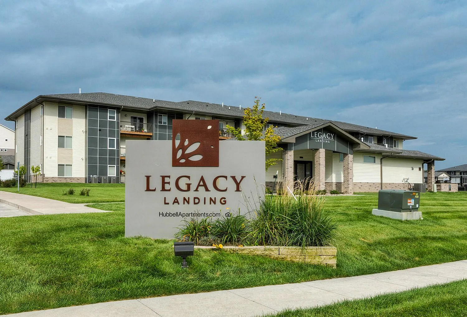 Welcoming façade of Legacy Landing apartments, surrounded by lush greenery and modern architecture, epitomizing luxury living.