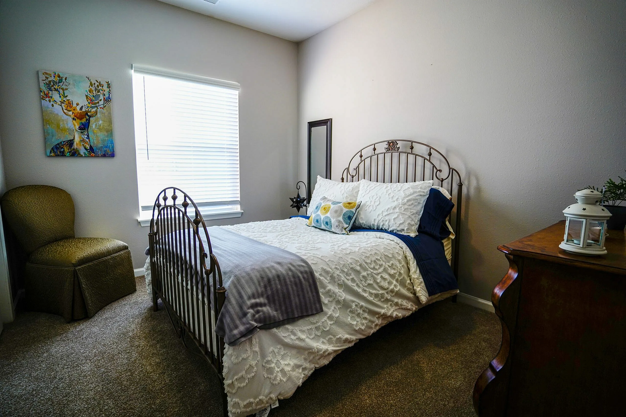 Cozy bedroom with elegant metal bed frame, bright window, and chic wall art.