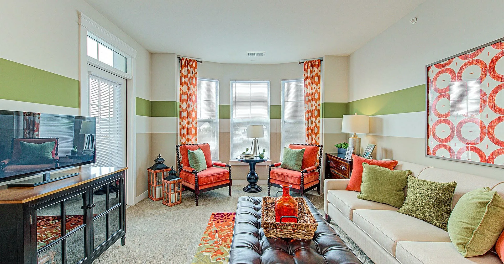 Chic living room with vibrant decor, featuring colorful cushions, modern artwork, and ample natural light, creating a cozy atmosphere.