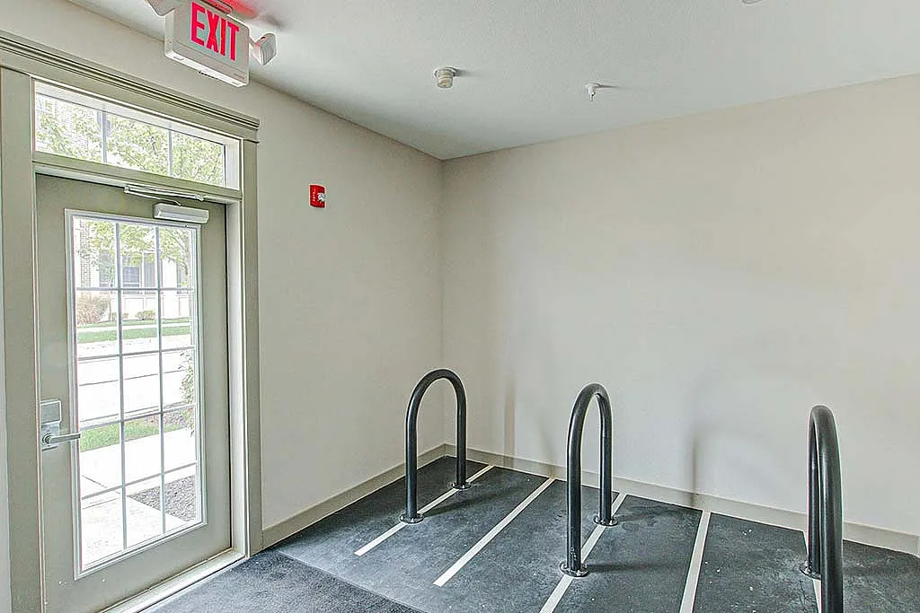 Inviting indoor bike storage area with convenient exit and bright natural lighting.