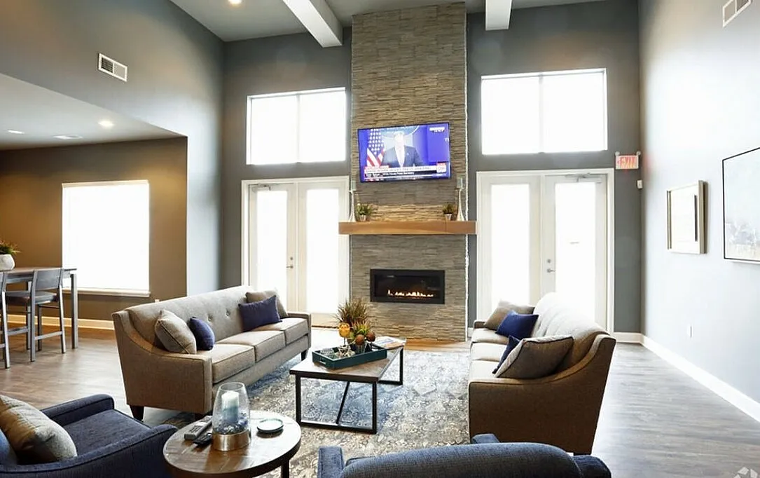 Contemporary living room with elegant sofas, a sleek fireplace, and large windows for natural light, perfect for stylish gatherings.