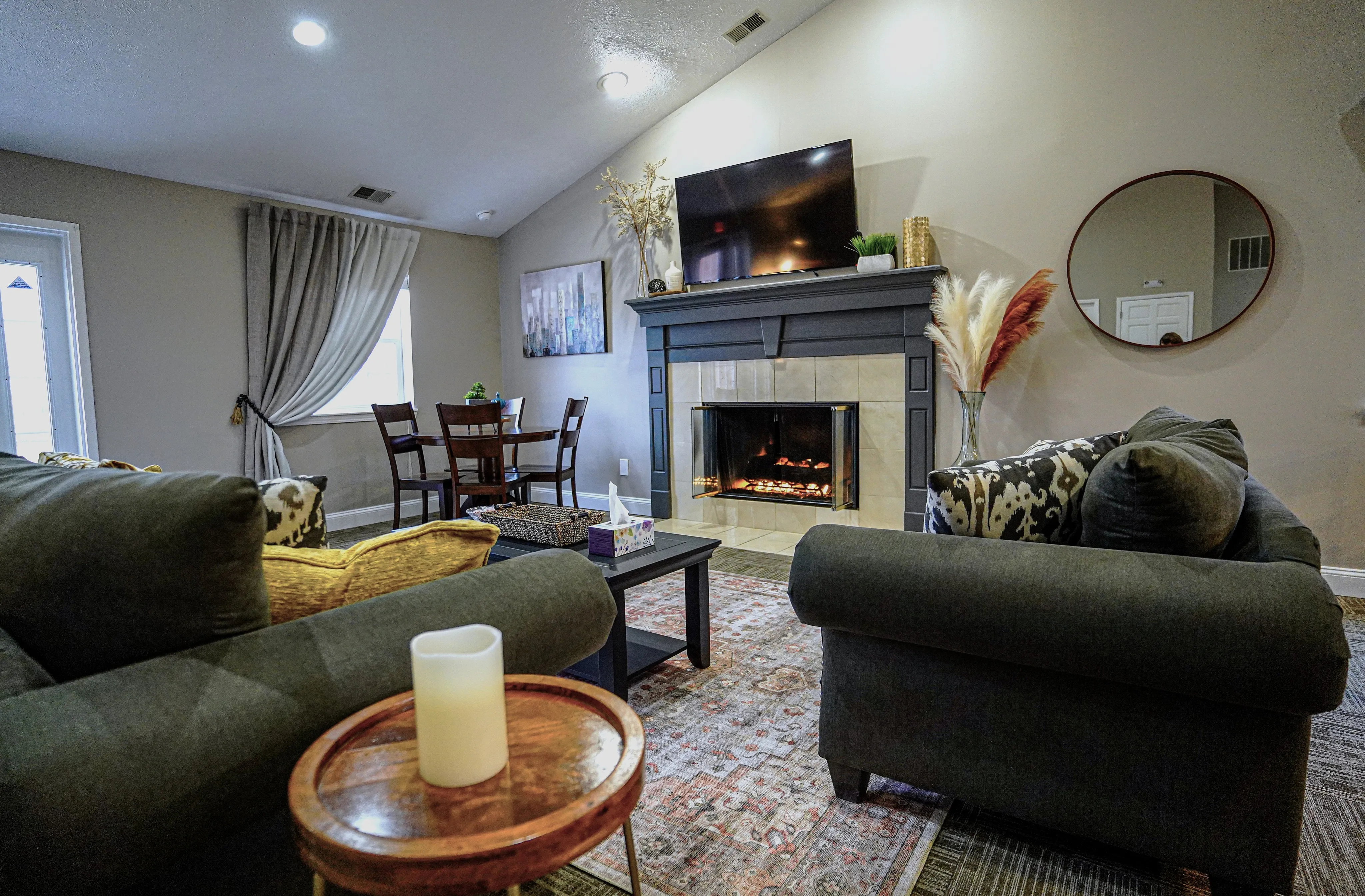 Cozy living room featuring a stylish fireplace, elegant seating, and a contemporary art piece with natural lighting.
