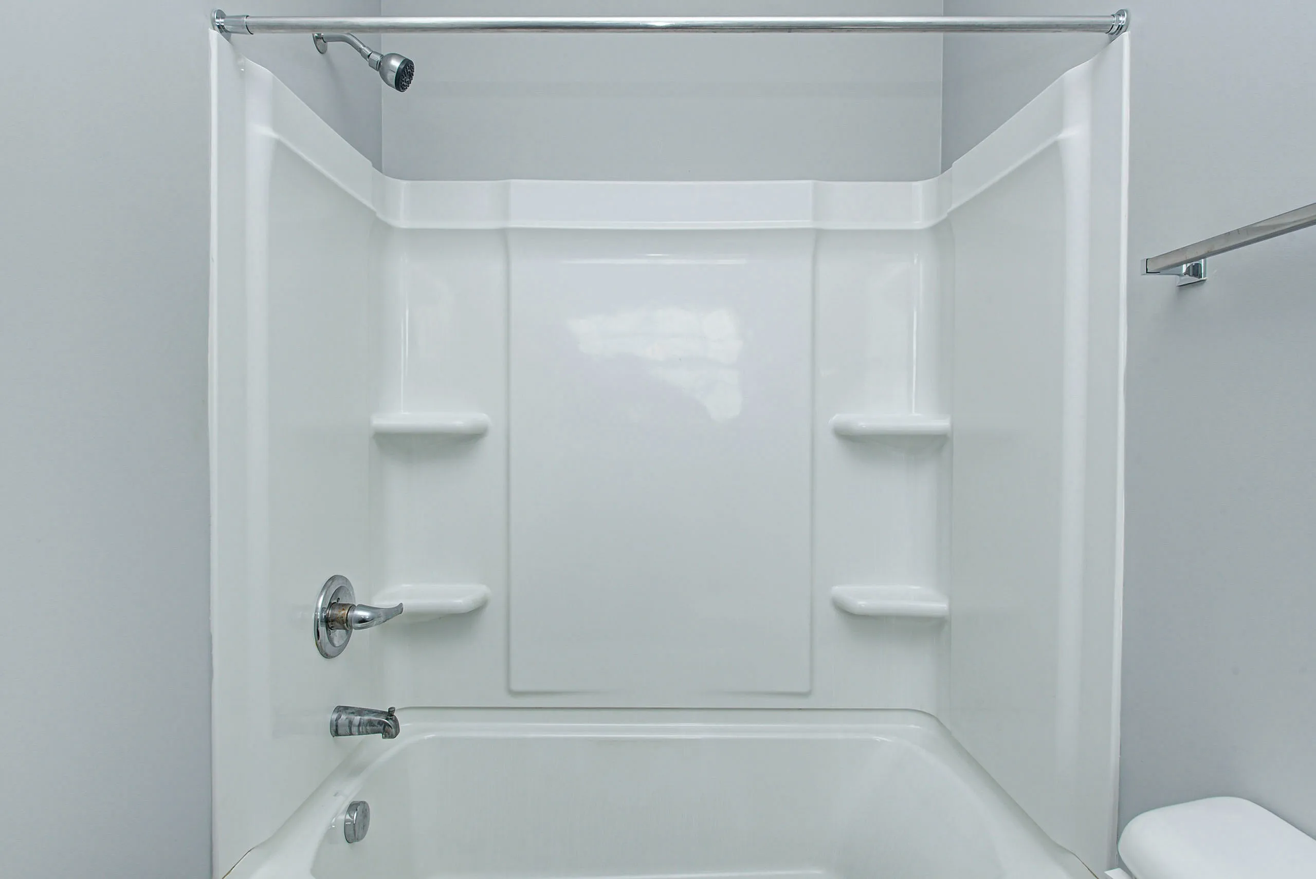 Pristine modern bathtub and shower combo with sleek white finish, perfect for a refreshing bathroom experience.