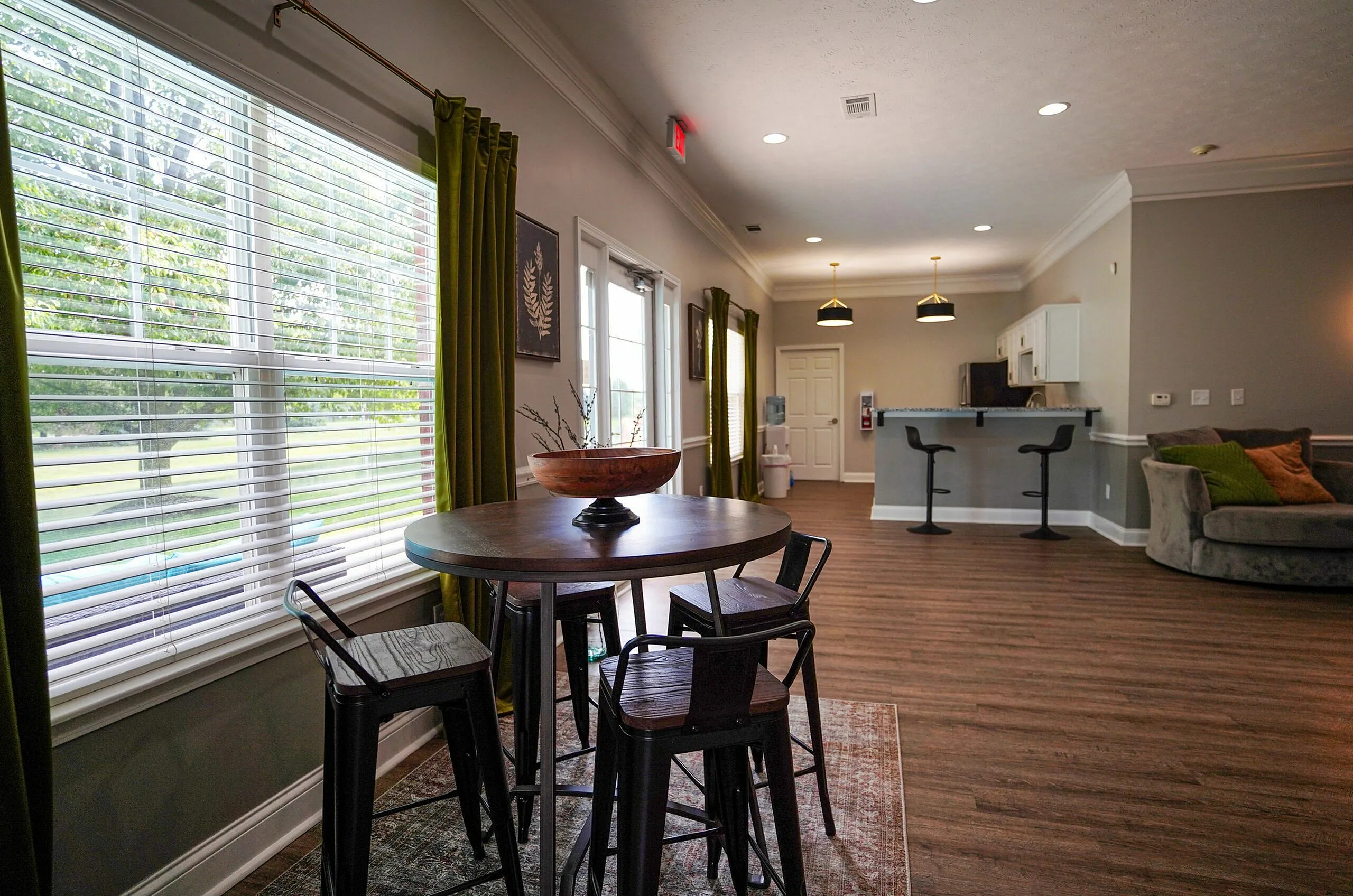 Modern open-concept living space with stylish dining area, large window for natural light, and a sleek kitchen with bar seating.