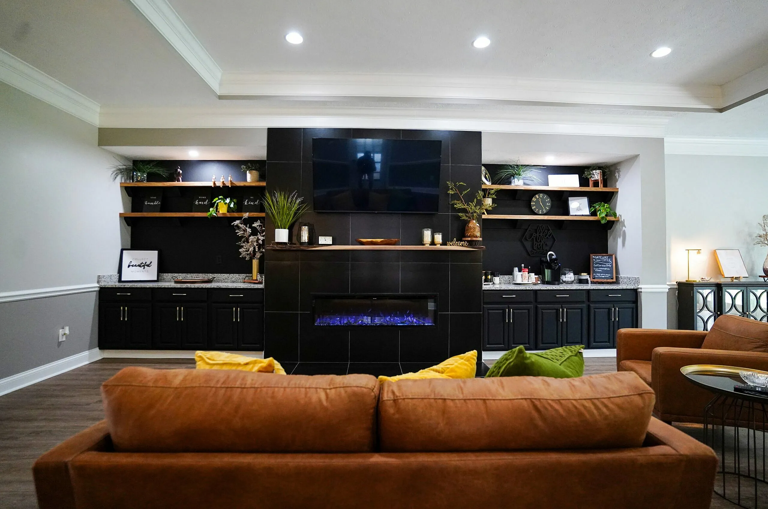 Chic living room with a modern fireplace, cozy brown couches, and stylish shelving, perfect for relaxation and entertaining.