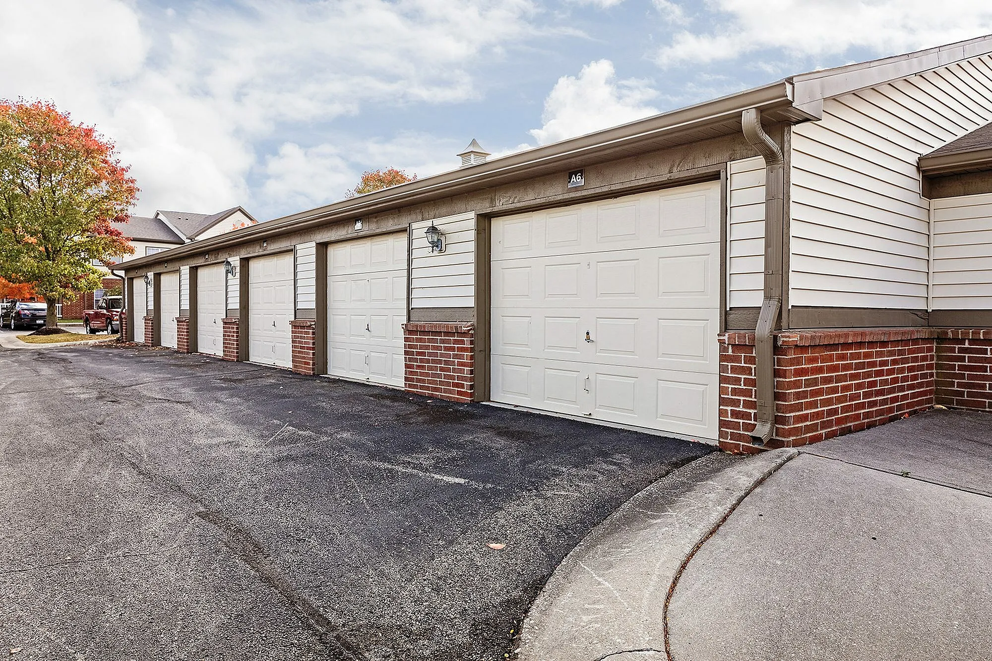 Attractive row of modern garages with brick accents and spacious driveways, perfect for secure and convenient parking.