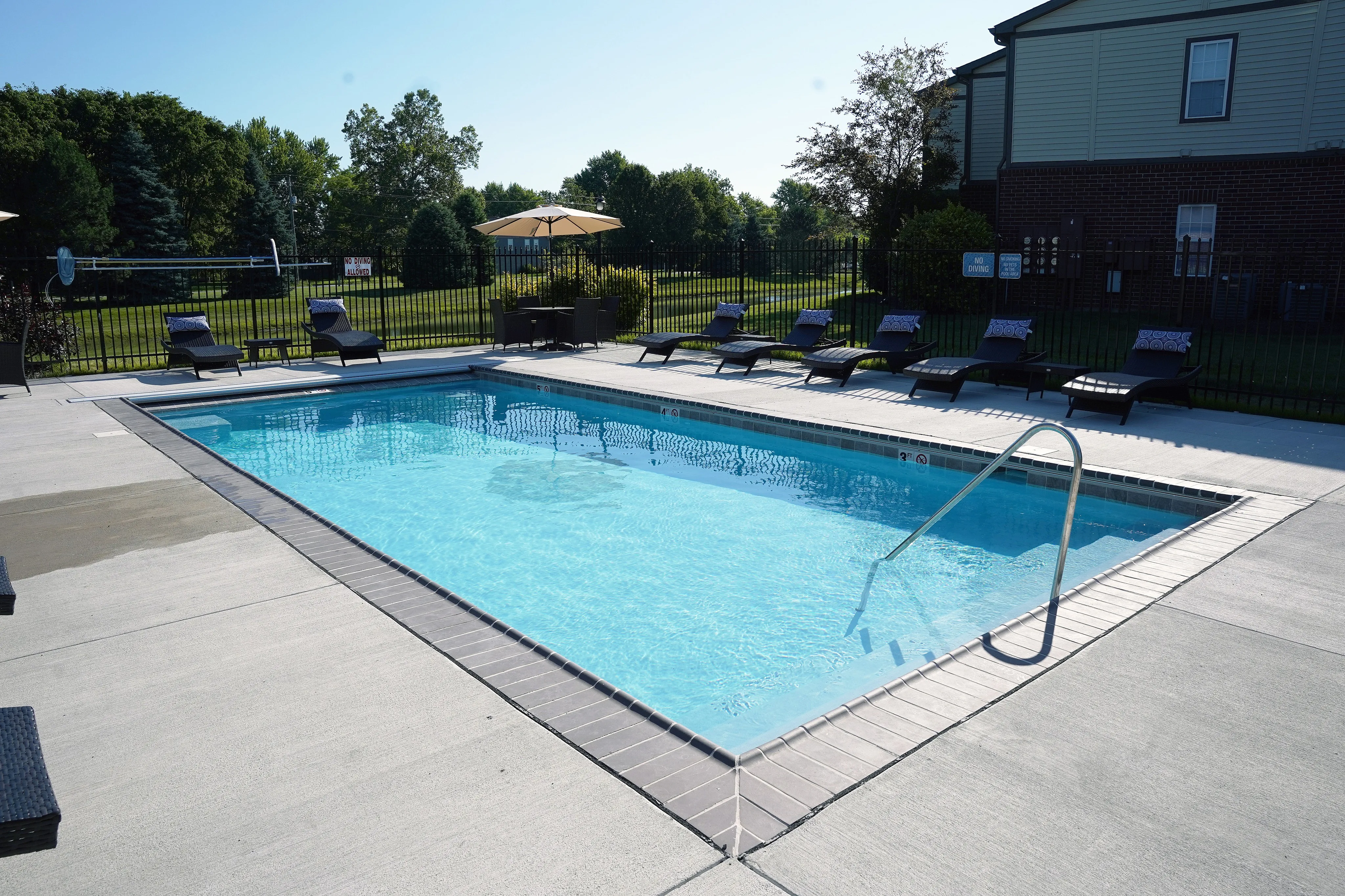 Inviting outdoor swimming pool surrounded by plush loungers, perfect for relaxation and enjoyment under the sun.