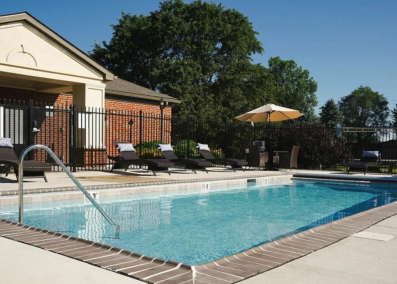Luxurious outdoor pool area with inviting lounge chairs and elegant landscaping, perfect for relaxing under the sun.