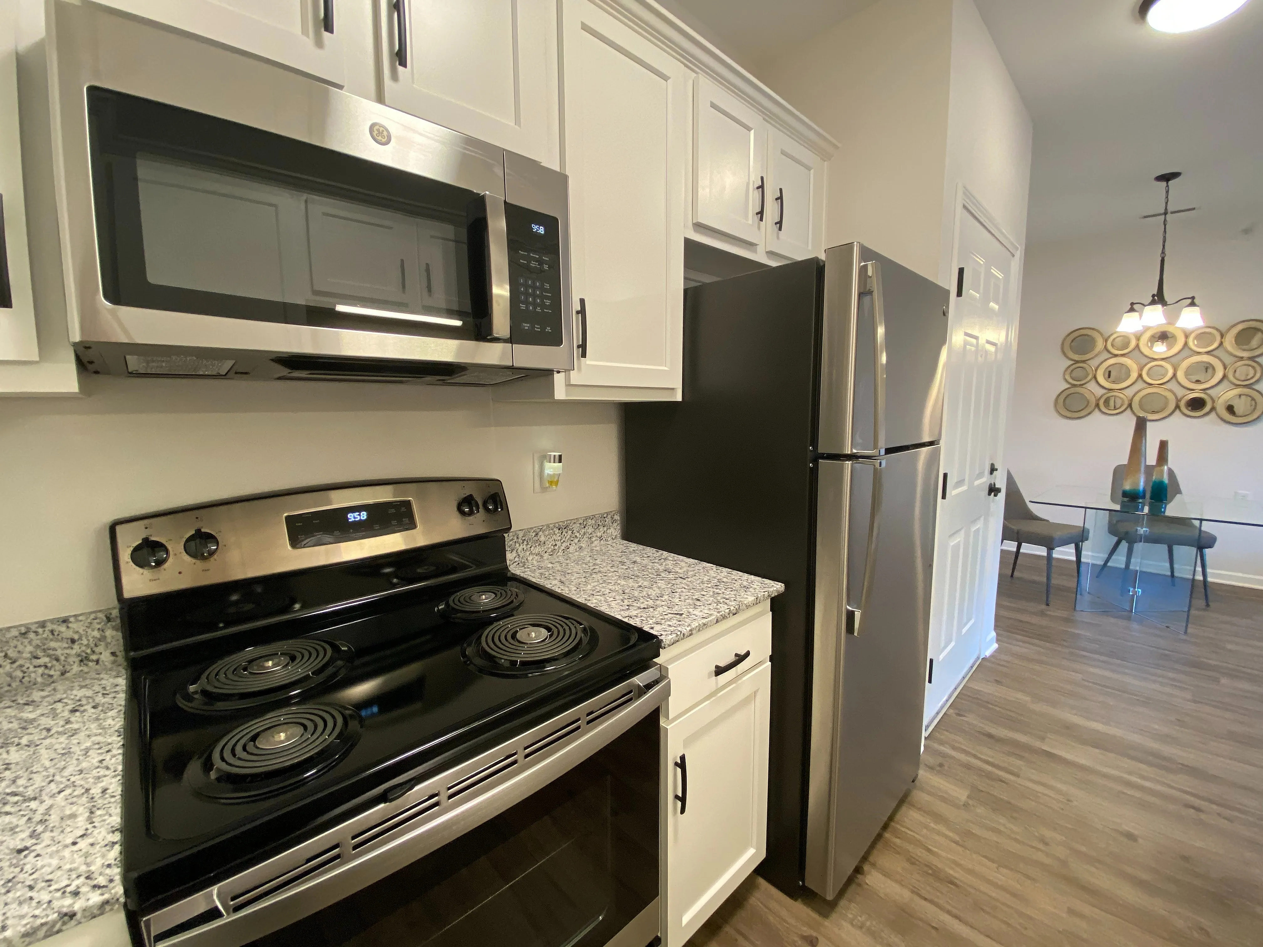 Modern kitchen with sleek stainless steel appliances, granite countertops, and a stylish dining area with chic decor.