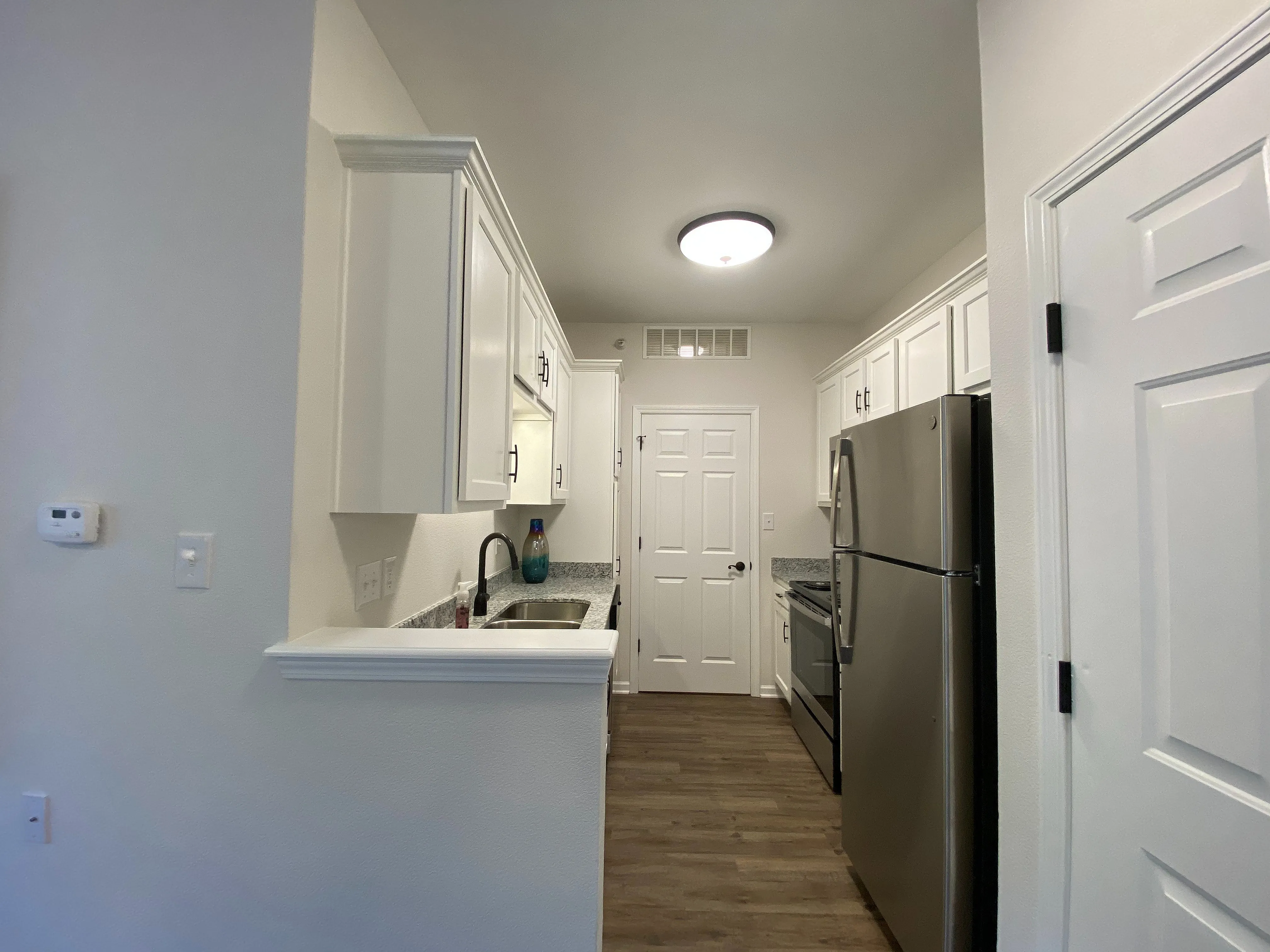 Sleek modern kitchen with stainless steel appliances, elegant cabinetry, and stylish wood flooring.