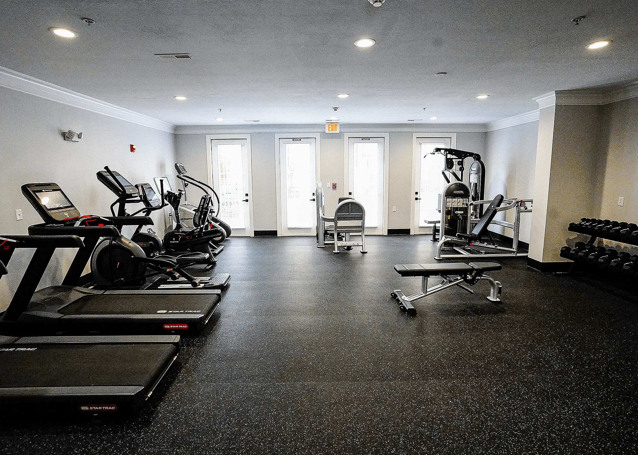 Modern fitness center with state-of-the-art treadmills, exercise bikes, weight machines, and free weights for a complete workout experience.