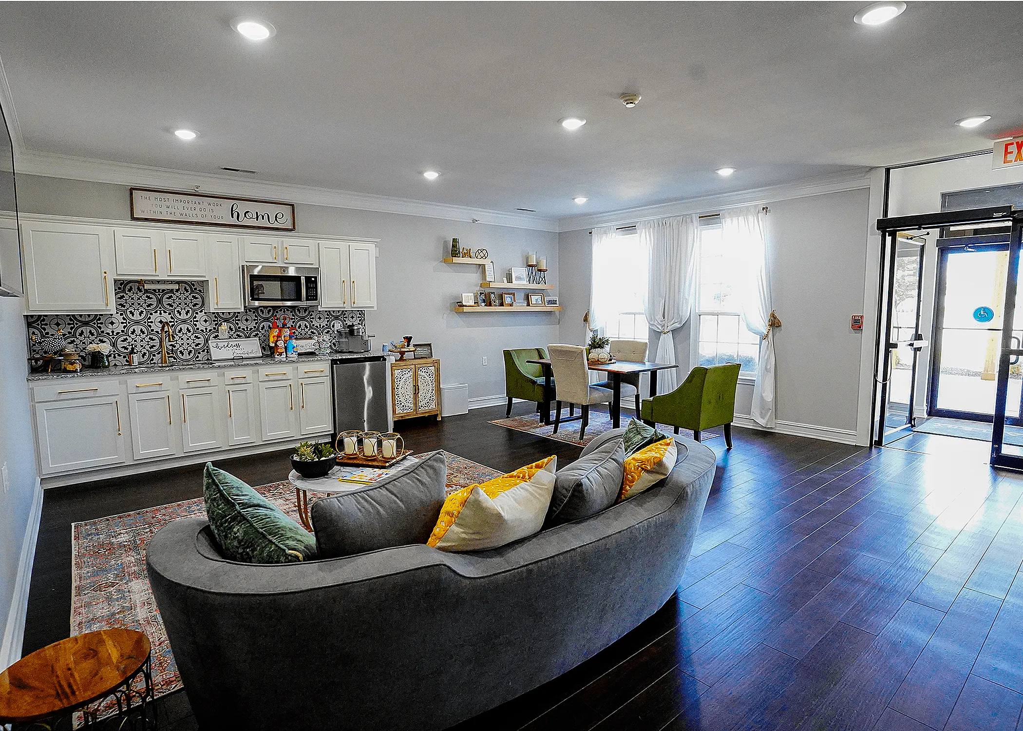 Chic open-plan interior featuring a stylish kitchen, cozy seating area, and inviting dining space with natural light streaming through large windows.